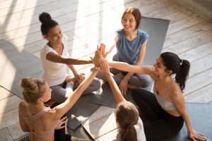 women high-fiving after yoga