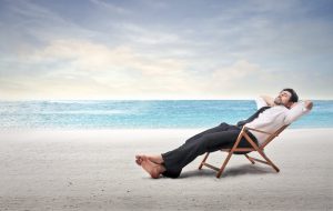 man in suit lounging on a beach