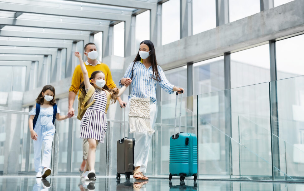 family walking through airport with masks on