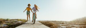 woman on bike and woman running on boardwalk