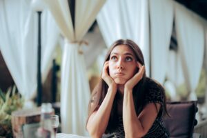 Unhappy young woman sitting at an wedding party event