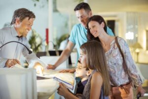 Family with two children at reception desk in hotel lobby