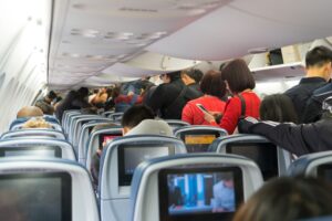 Los Angeles, USA 12, 2017: People are standing and sitting in an airplane cabin before disembarking. Interior of airplane with passengers getting off at Los Angeles, California.