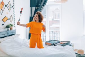 travel blogger recording video with cell phone in hotel room - social advisor vlogger holiday destinations