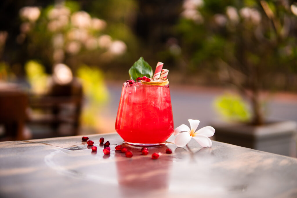 A non alcoholic tropical pomegranate mocktail drink, perfect for dry tripping.
