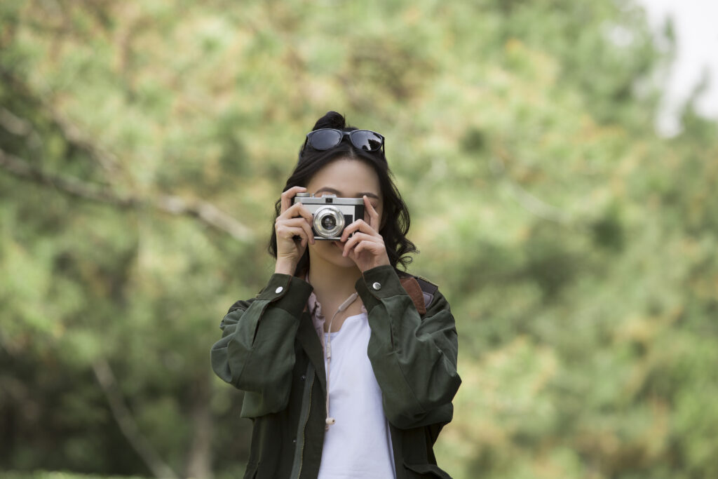 Influencer taking a picture of nature while enjoying her budget travel vacation.