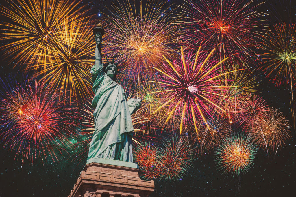 The Statue of Liberty in front of a colorful display of fireworks in the night sky, foreshadowing America's 250th.