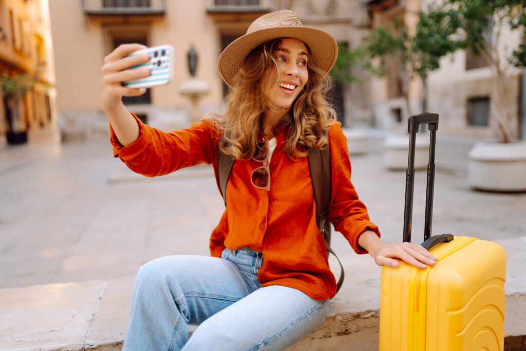 Young woman with phone is blogging, creating content for social search optimization, while enjoying a trip on sunny day.