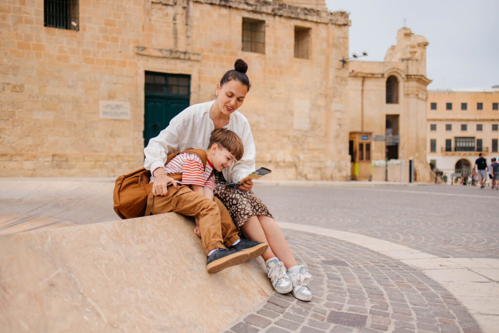 A mom and her son, happily at a tourist destination reviewing a map to decide where to go next.
